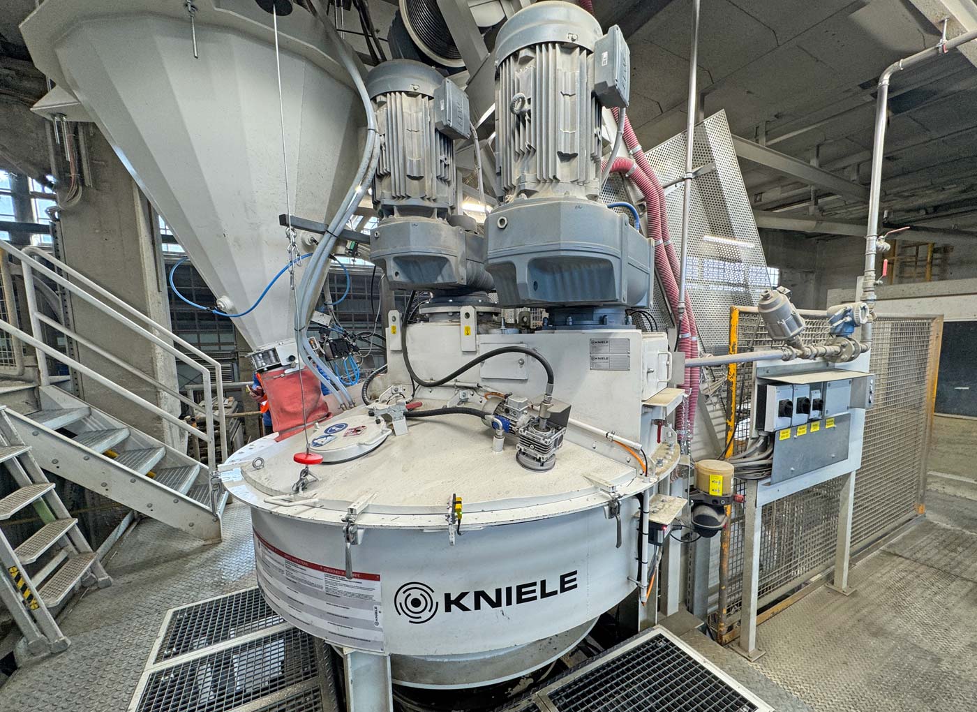 Weißer Kniele Konusmischer mit Zementwaage auf der linken Seite und Wasserdosierung rechts