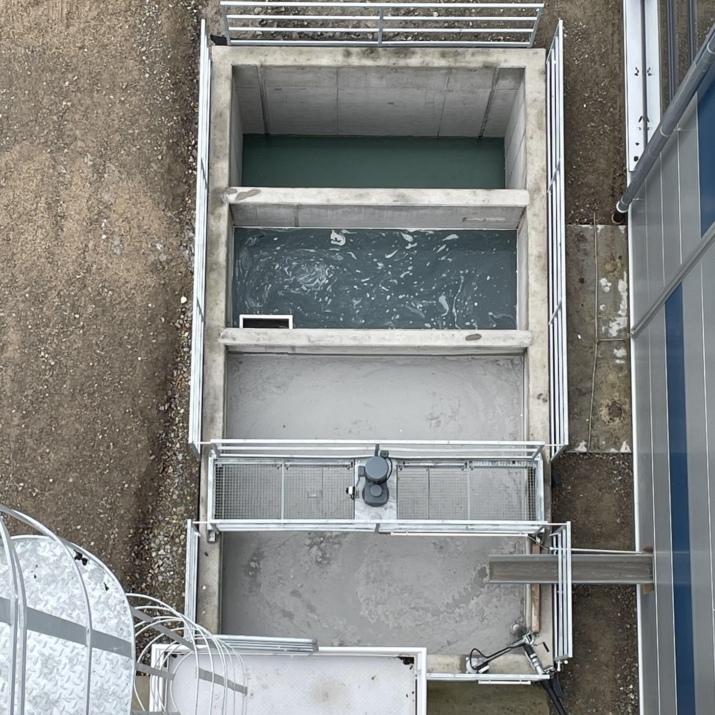 Top view of a multi-chamber settling tank at a water treatment plant, with concrete tanks and walkways.