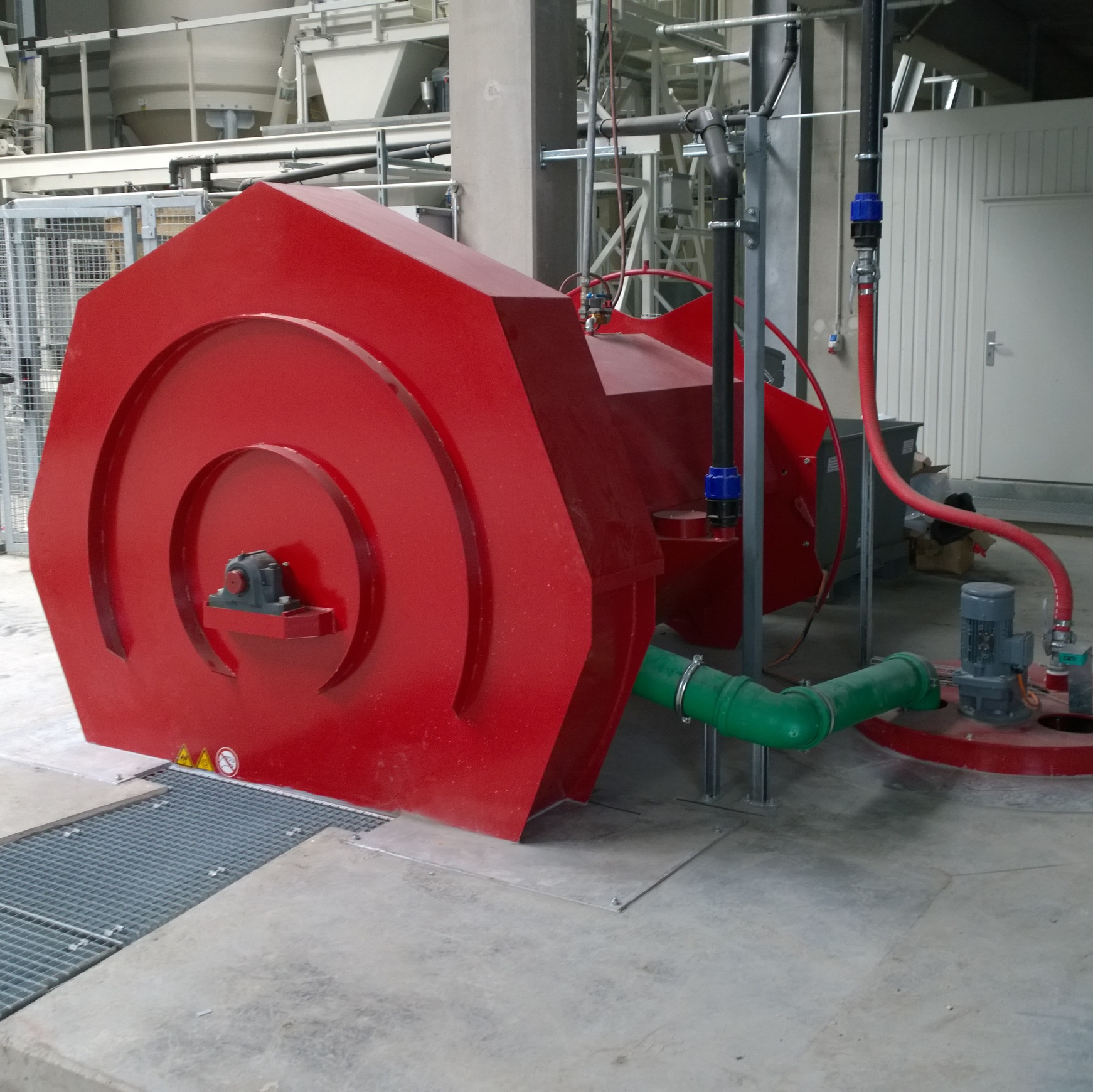 Front view of an industrial washer for material processing, with connected pipework.