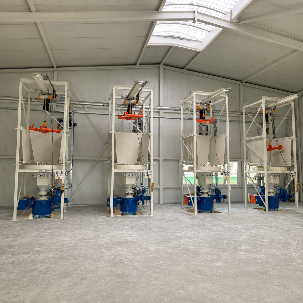 Four white big-bag stations with cranes lined up in a row, orange crossbeams and blue loading bellows.